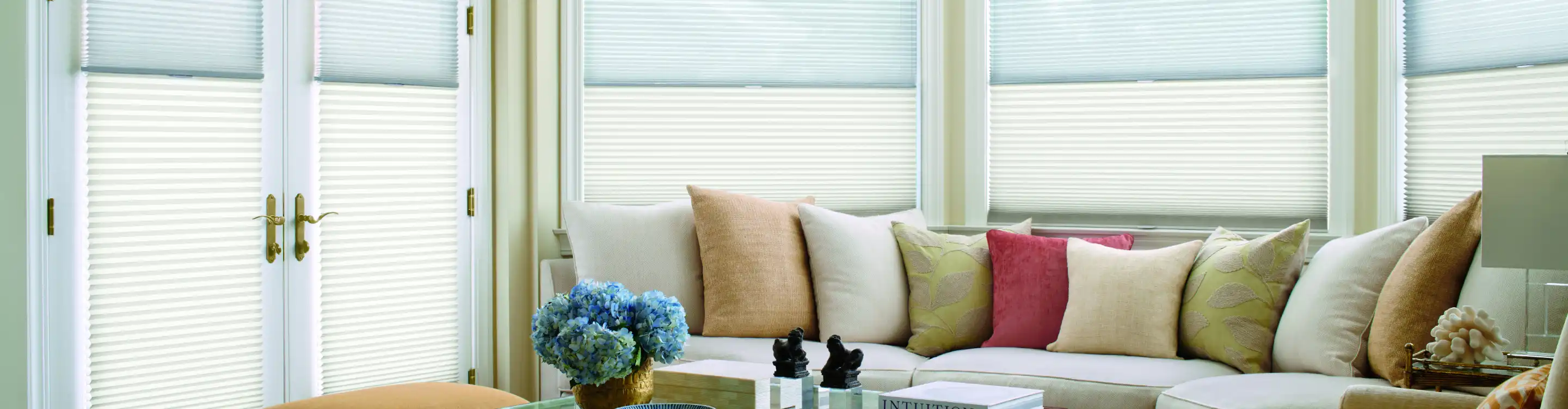 Hunter douglas blinds with colorful throw pillows and couch. 